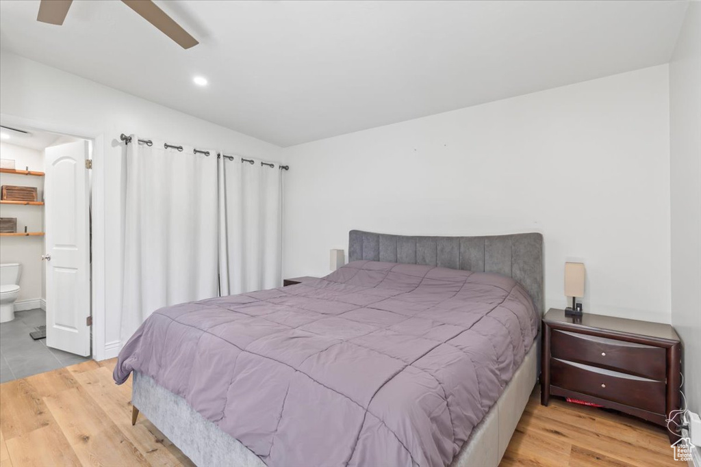 Bedroom with wood finished floors, ensuite bath, recessed lighting, vaulted ceiling, and ceiling fan