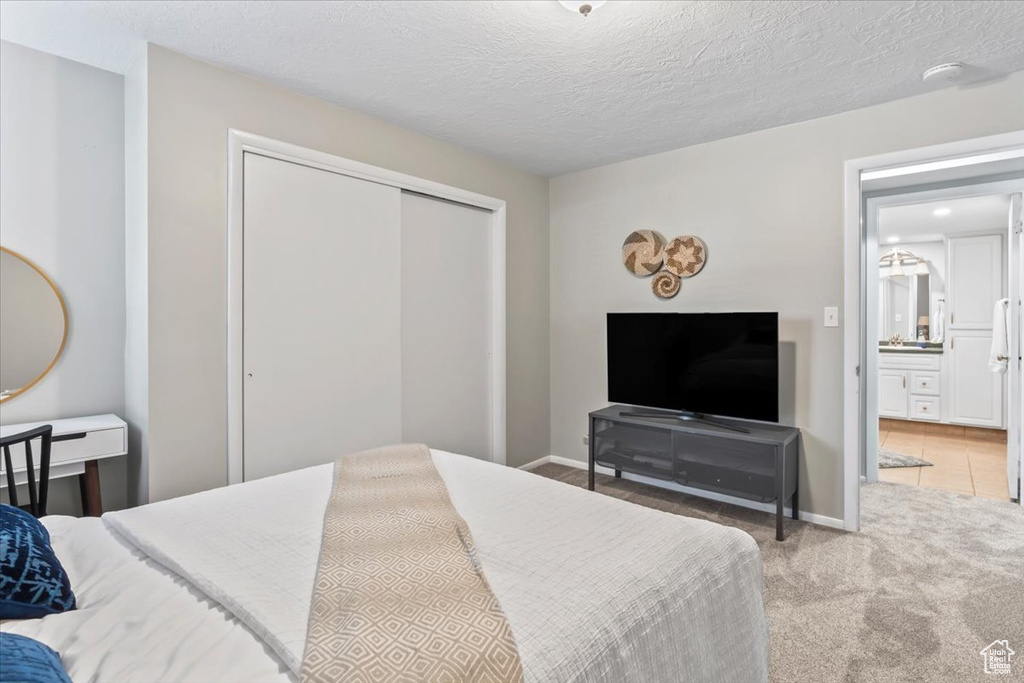 Carpeted bedroom featuring a closet and baseboards