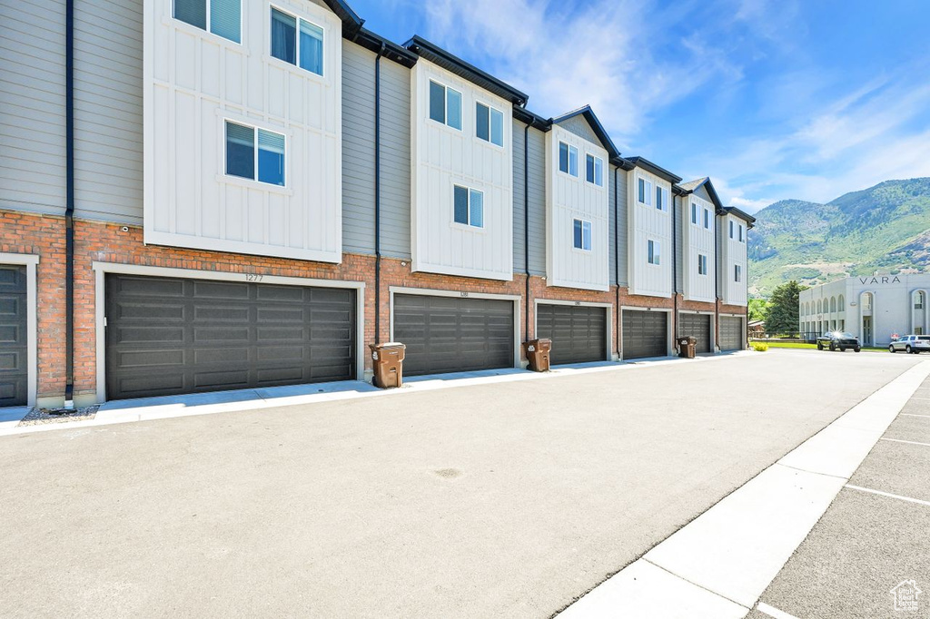 View of property featuring a mountain view, an attached garage, and a residential view