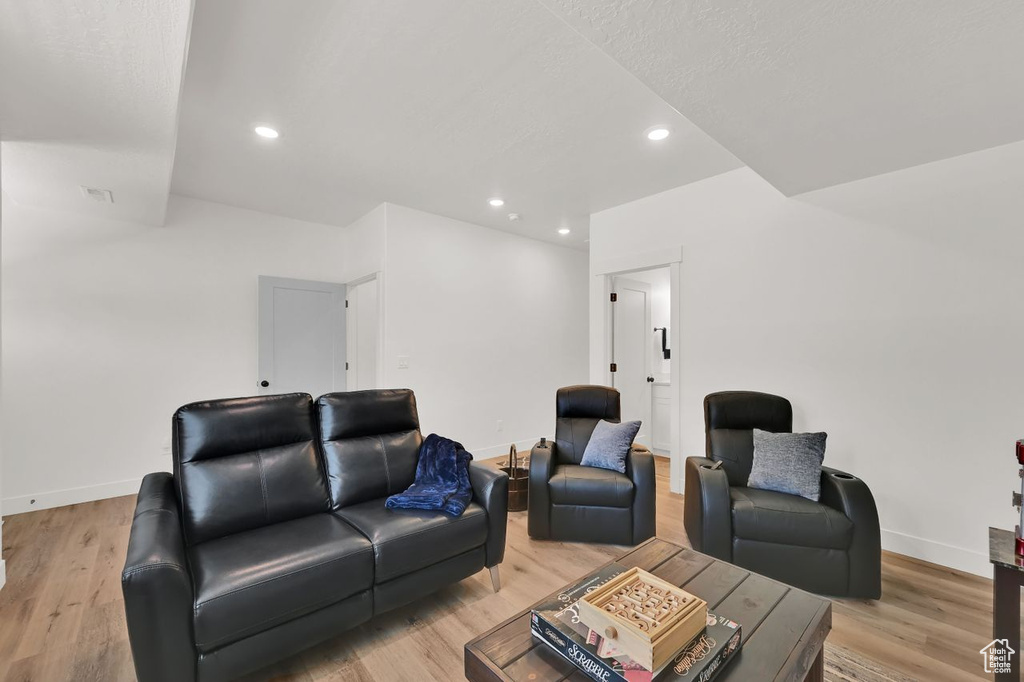 Living area with light wood-style floors and recessed lighting