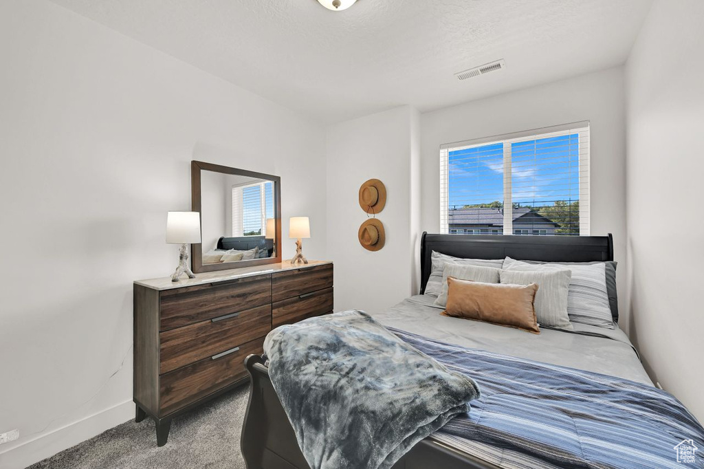 Bedroom featuring carpet and baseboards