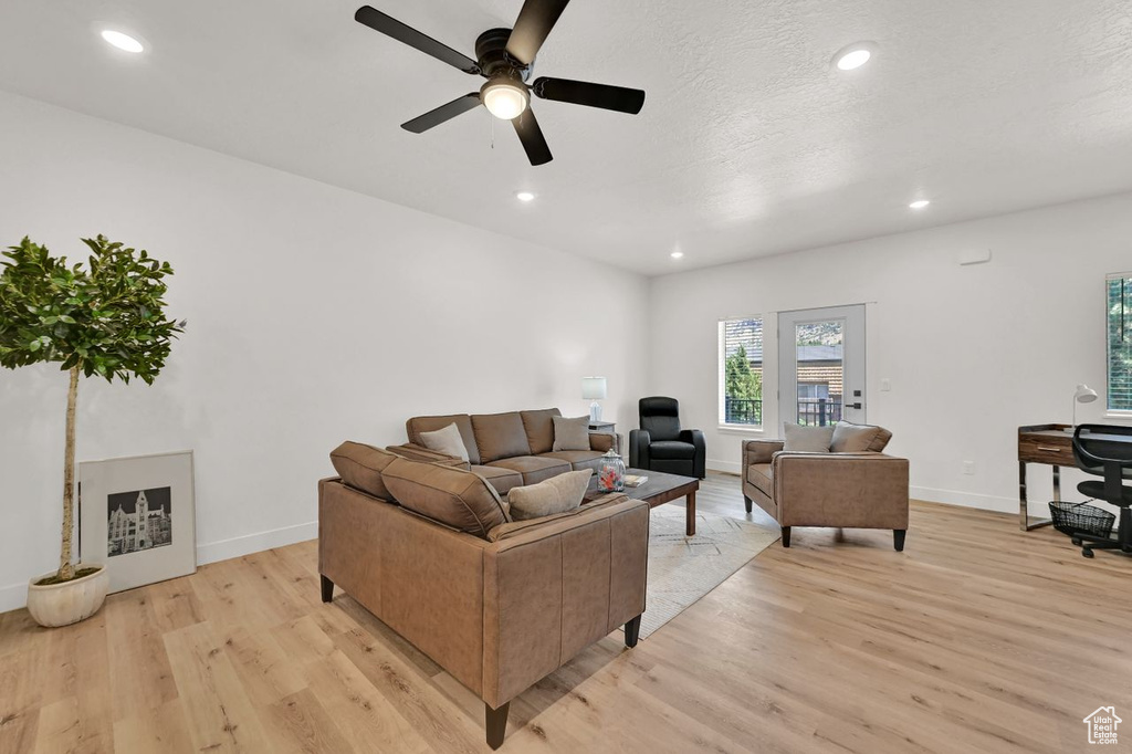 Living area with light wood-style flooring, a ceiling fan, and recessed lighting
