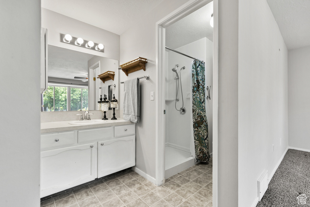 Bathroom featuring vanity, a shower with curtain, and ceiling fan