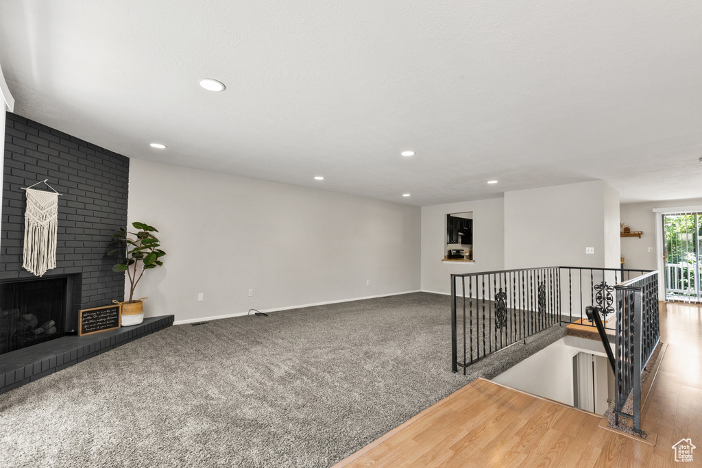 Unfurnished living room featuring recessed lighting, a fireplace, and carpet floors