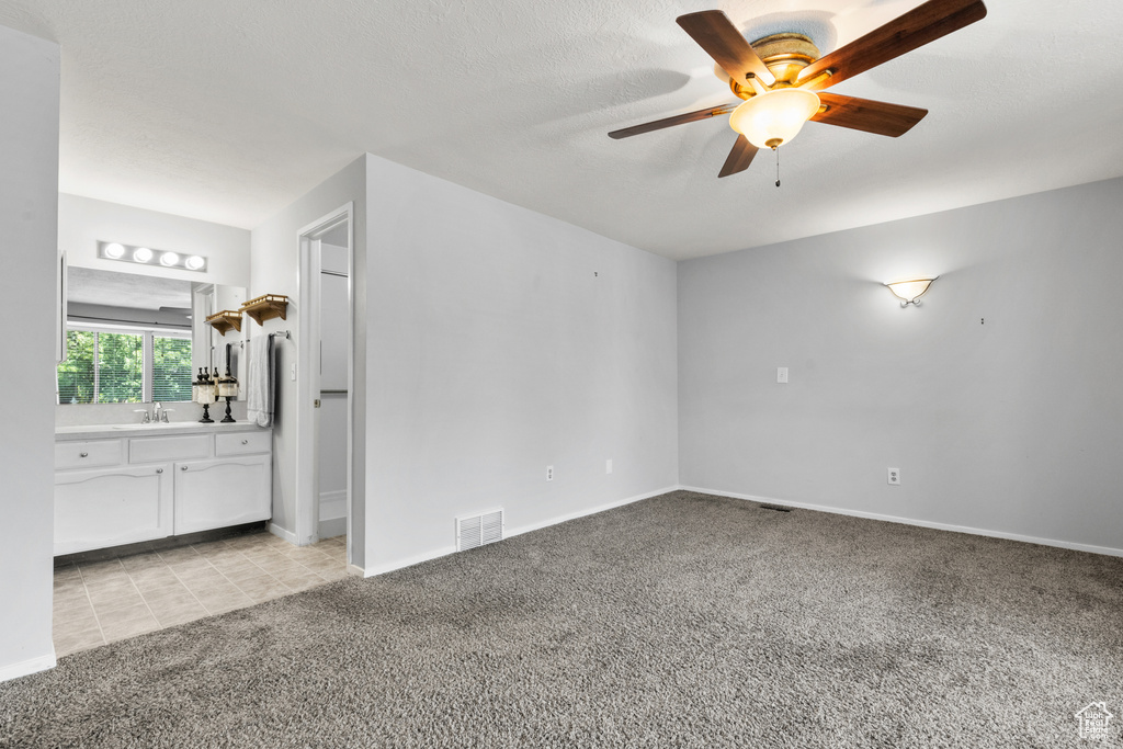 Empty room with light carpet and ceiling fan