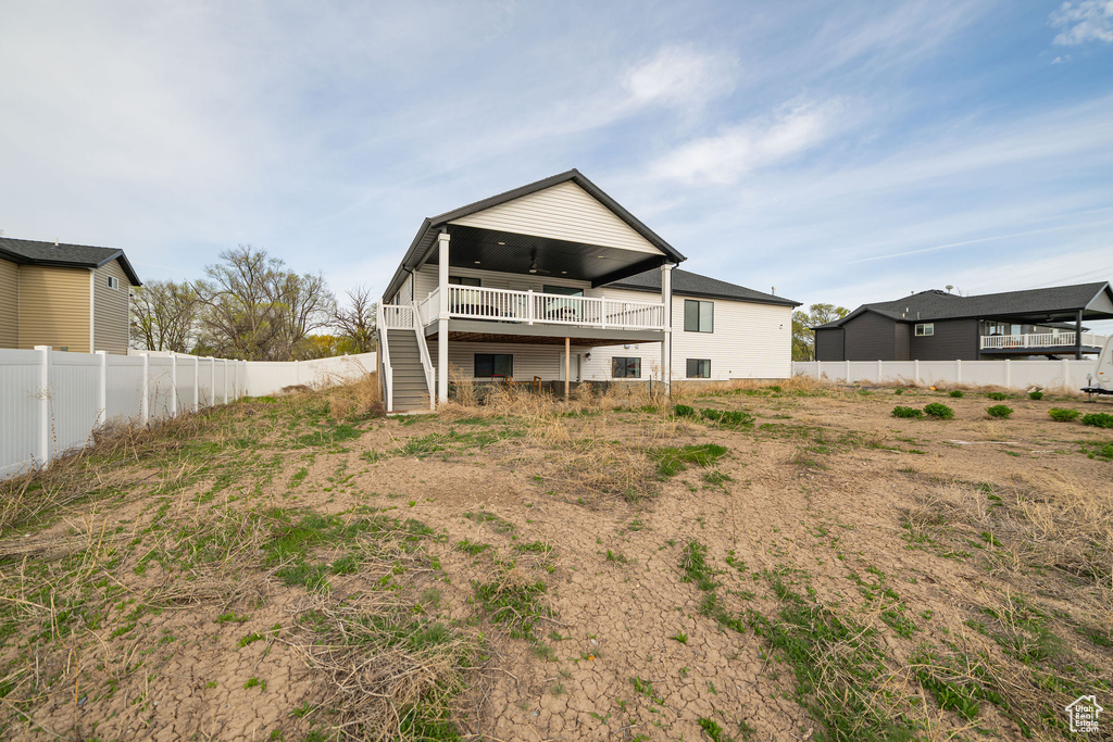 Back of property with stairs, a ceiling fan, and a wooden deck