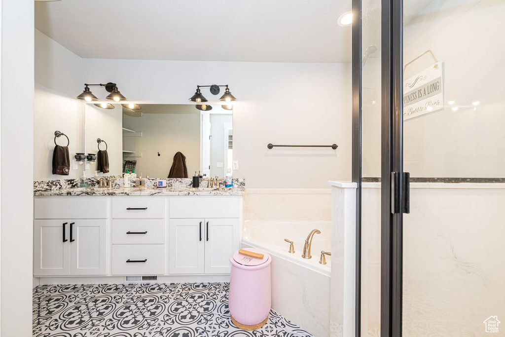Bathroom with double vanity, a bath, tile patterned floors, and an enclosed shower