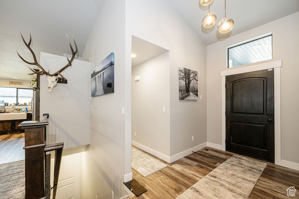 Foyer with wood finished floors and high vaulted ceiling