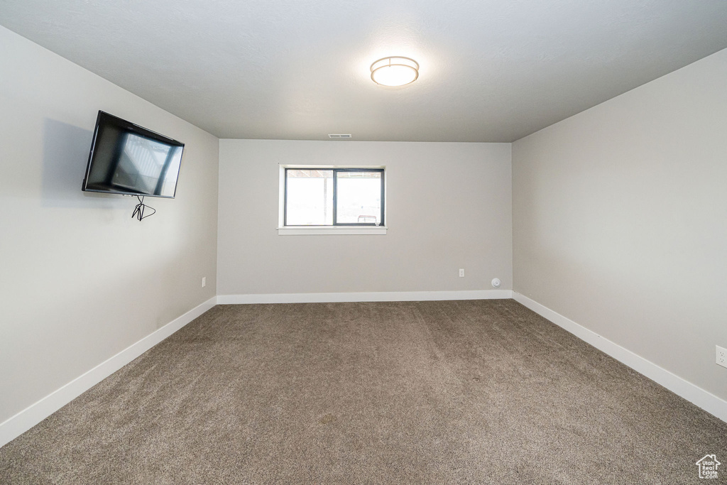 Spare room featuring carpet floors and baseboards