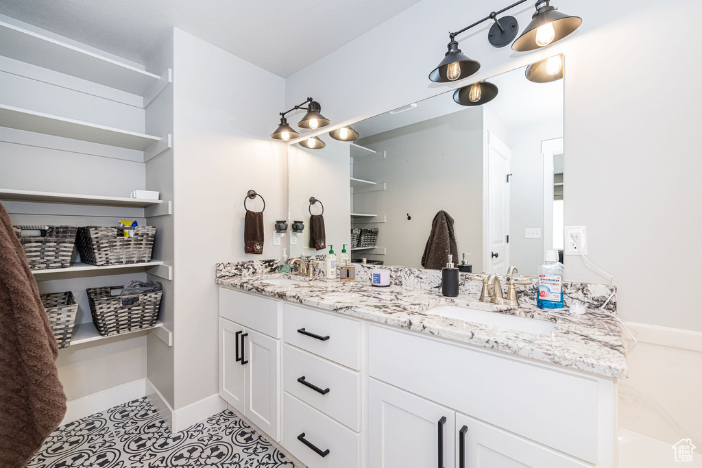 Full bathroom with double vanity and tile patterned flooring