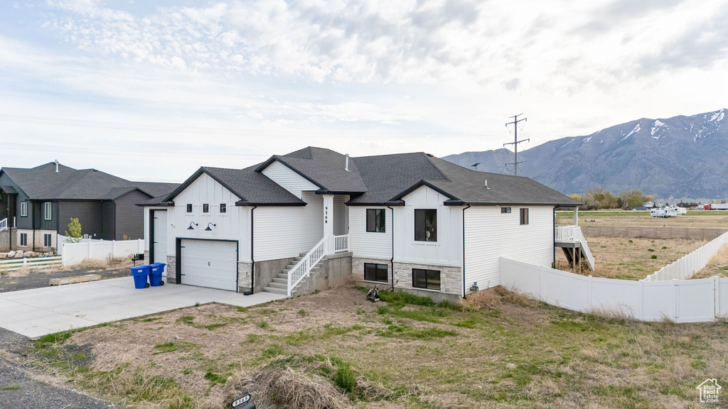 View of front of home featuring board and batten siding, driveway, and a mountain view