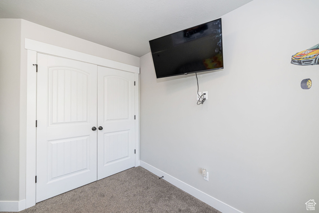 Unfurnished bedroom with carpet and a closet