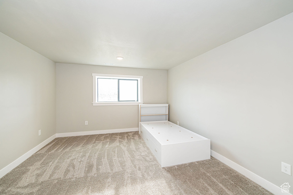 Unfurnished bedroom with light colored carpet