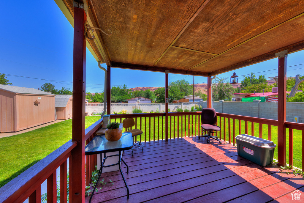 Wooden terrace with a fenced backyard and a storage shed