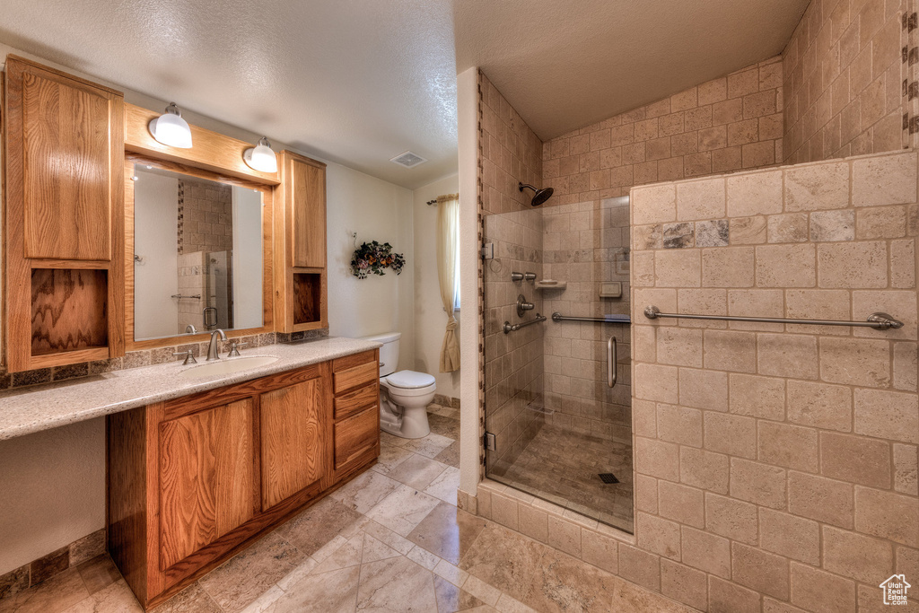 Bathroom featuring a shower stall and vanity