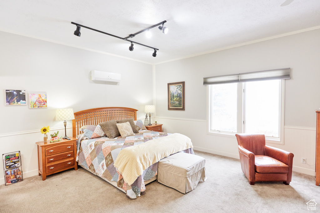 Bedroom with rail lighting, a wall mounted AC, and carpet