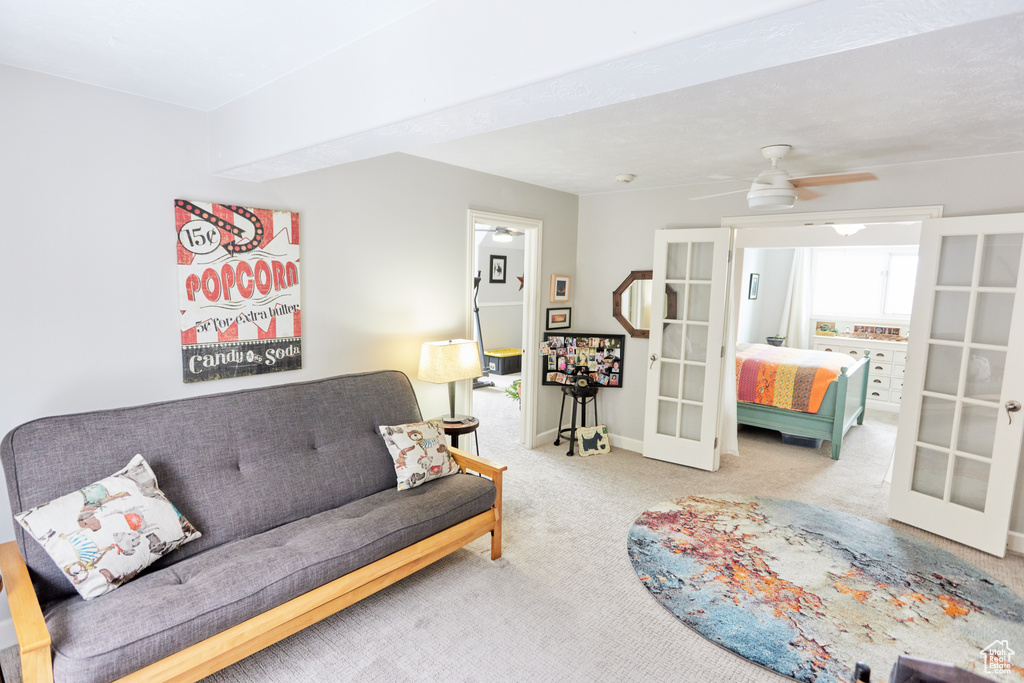 Carpeted living area with french doors and a ceiling fan
