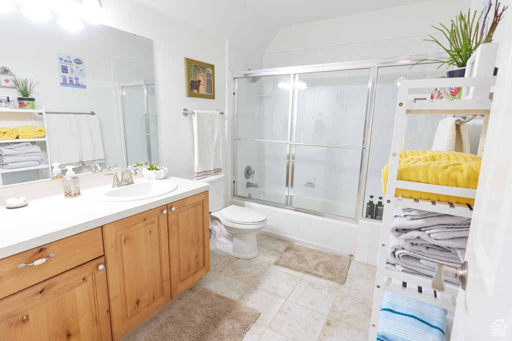 Full bathroom with vanity, shower / bath combination with glass door, and tile patterned floors