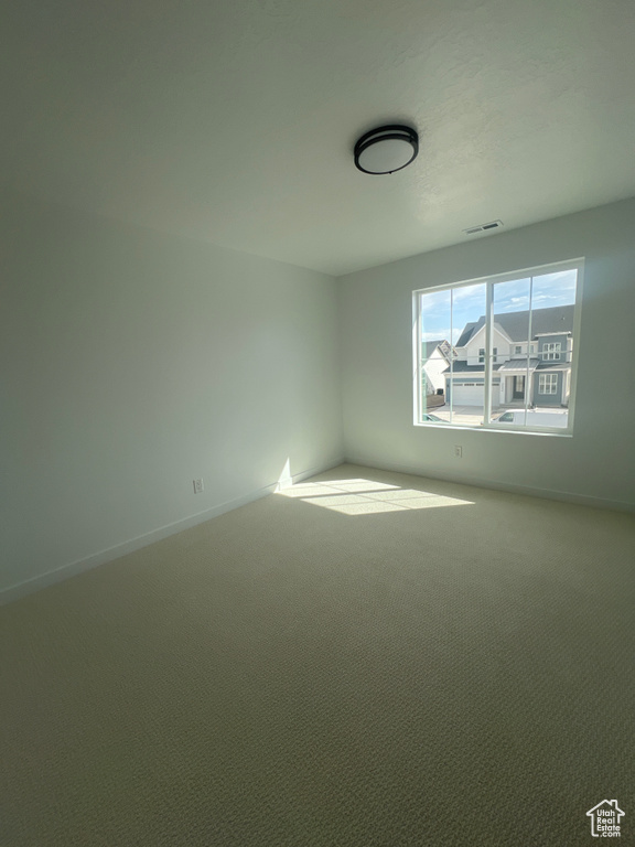 Unfurnished room featuring carpet and baseboards