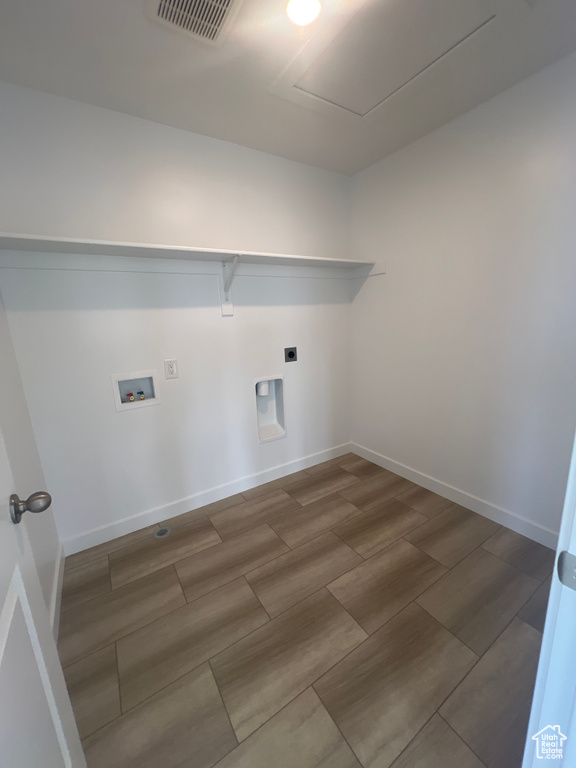 Washroom featuring hookup for a washing machine, wood finish floors, and hookup for an electric dryer