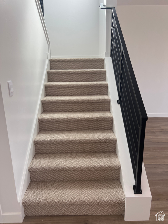 Stairs with wood finished floors and baseboards