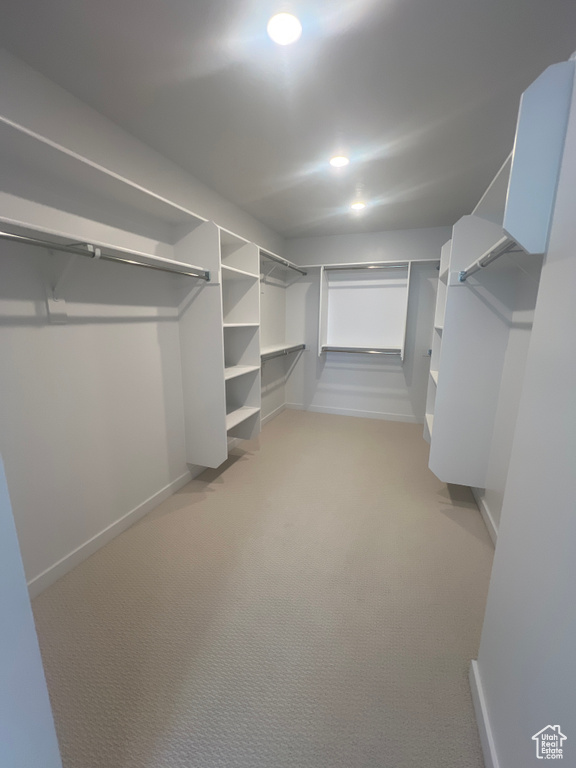 Walk in closet featuring light colored carpet