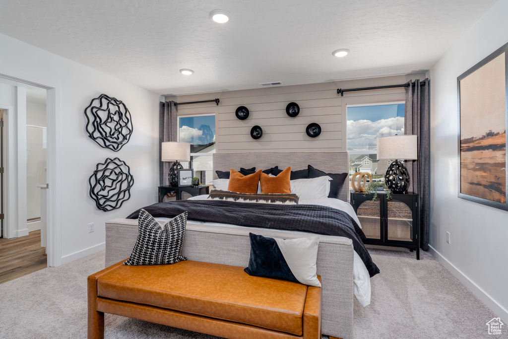 Carpeted bedroom featuring multiple windows and recessed lighting