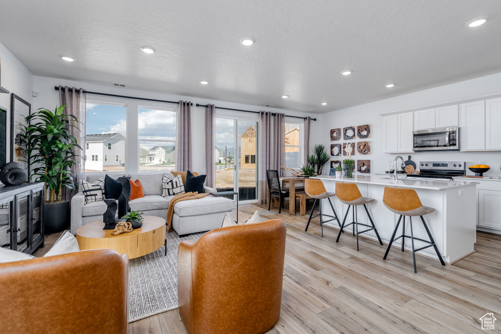 Living room with recessed lighting and light wood-type flooring