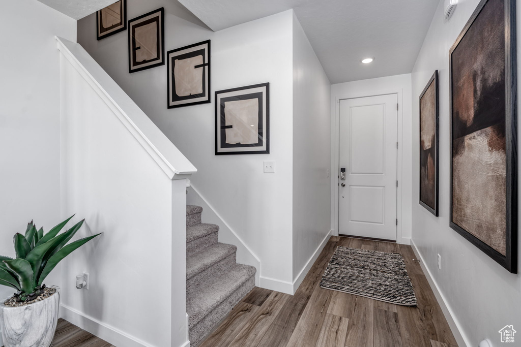 Foyer featuring wood finished floors, stairway, and recessed lighting