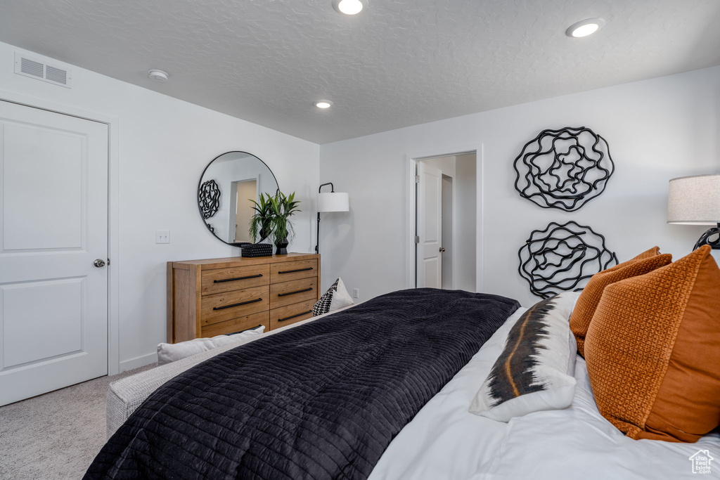 Bedroom with carpet, recessed lighting, and a textured ceiling
