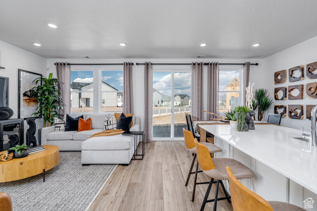 Living area with light wood-style floors and recessed lighting