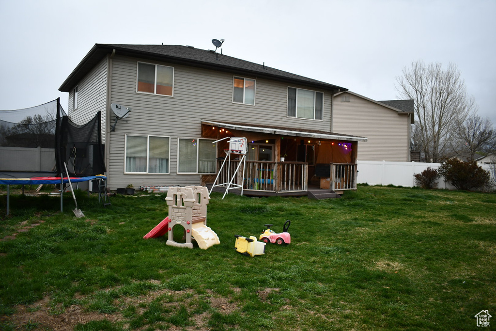 Rear view of property featuring a trampoline