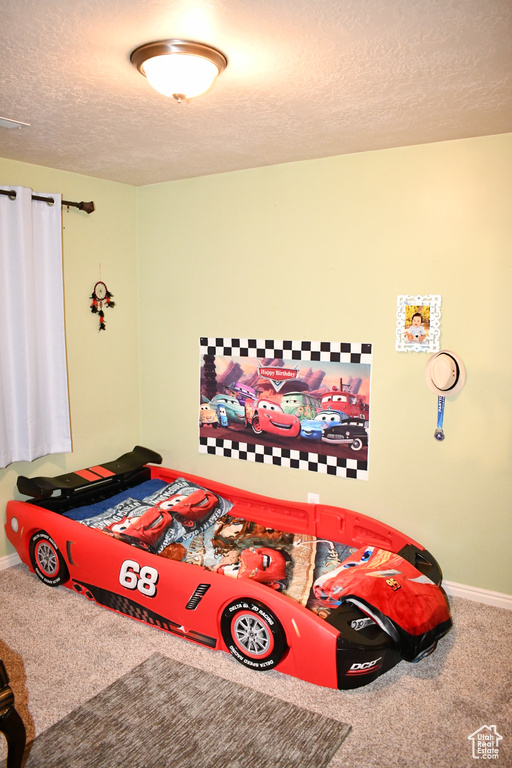 Bedroom featuring carpet floors and a textured ceiling