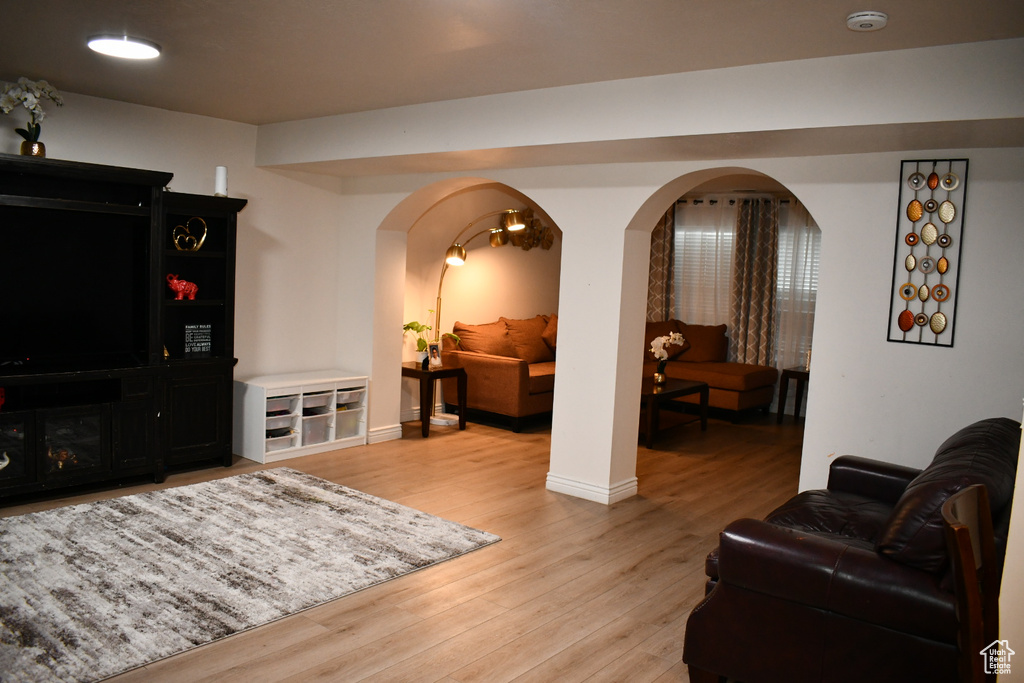 Living room with arched walkways and light wood-style flooring