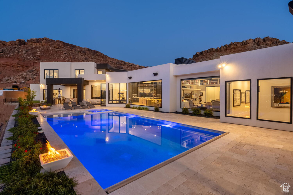 Outdoor pool featuring an outdoor fire pit, a mountain view, a patio area, and a hot tub