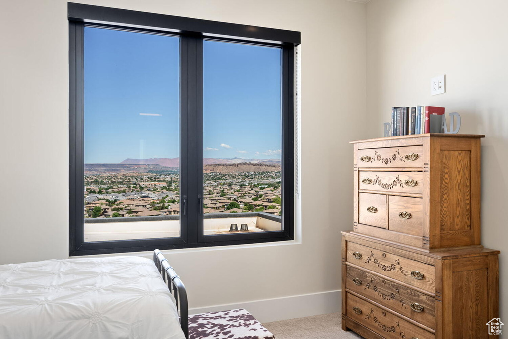 Carpeted bedroom featuring baseboards and a mountain view