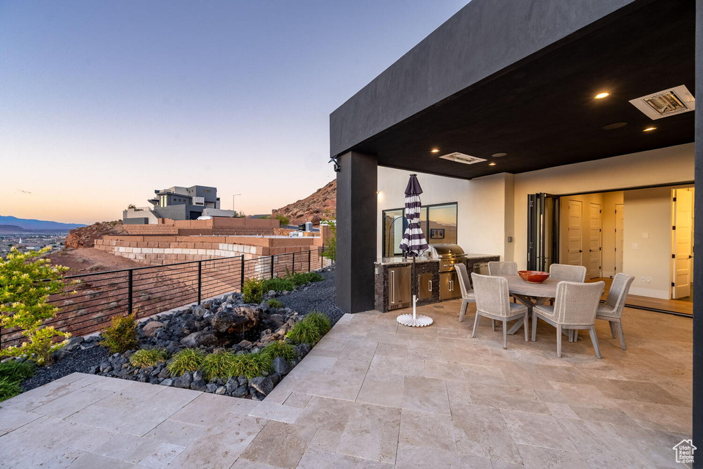 Patio terrace at dusk with area for grilling, a patio, and outdoor dining area
