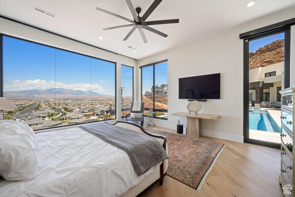 Bedroom with wood finished floors, multiple windows, recessed lighting, and ceiling fan