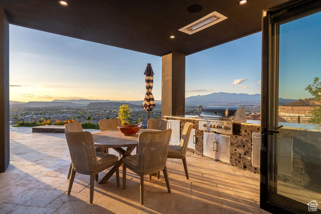 View of patio / terrace with area for grilling, outdoor dining area, and a mountain view
