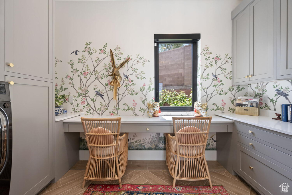Dining space with built in study area, wallpapered walls, healthy amount of natural light, and washer / dryer