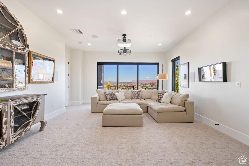 Carpeted living area featuring recessed lighting and baseboards
