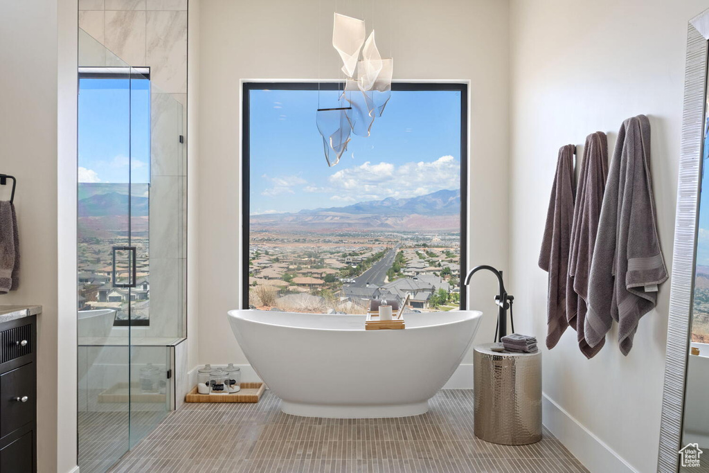Full bath featuring a freestanding bath, tile patterned floors, a stall shower, vanity, and a mountain view