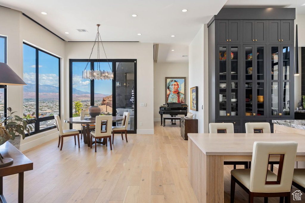 Dining room featuring a chandelier, light wood-style floors, recessed lighting, and healthy amount of natural light