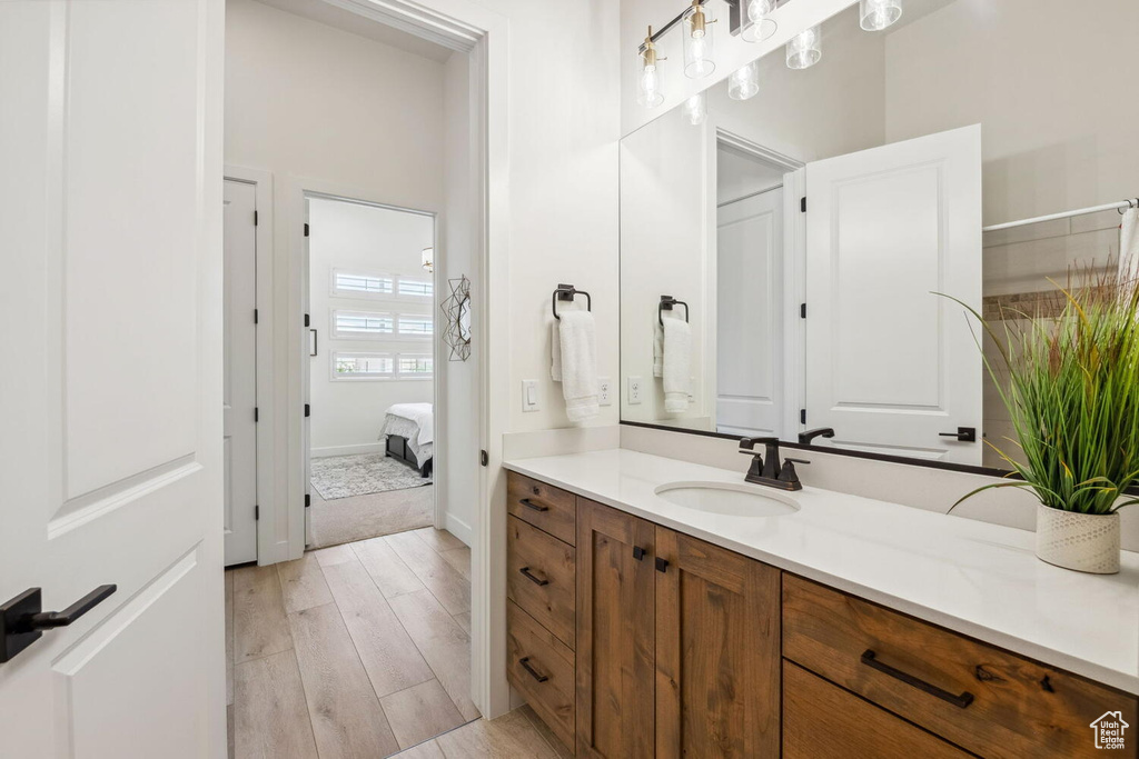 Ensuite bathroom featuring vanity and wood finished floors