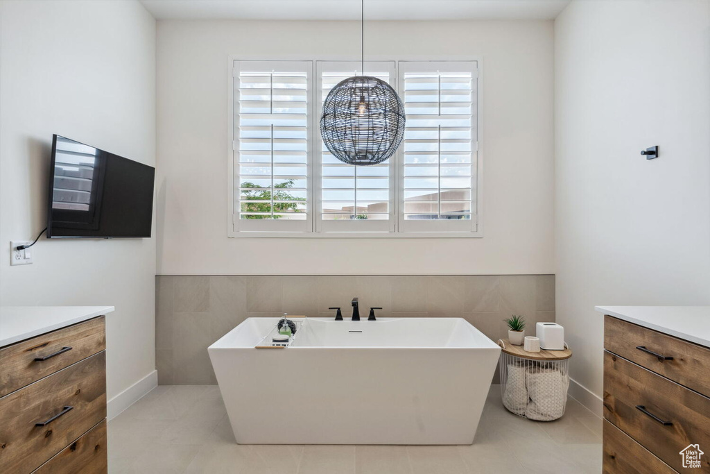 Full bathroom featuring vanity, a freestanding tub, and tile patterned flooring