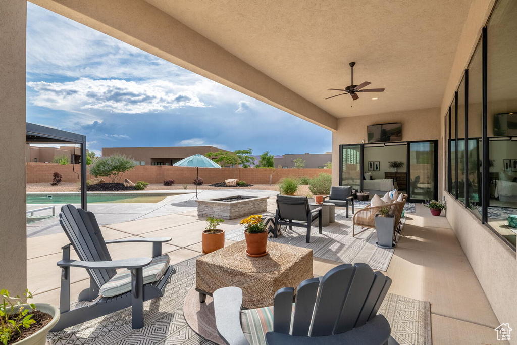 Fenced backyard featuring a patio area, outdoor lounge area, and a ceiling fan