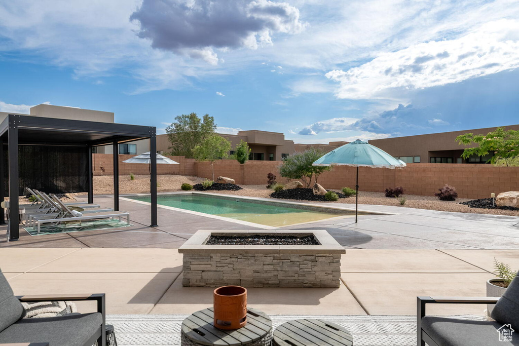 Fenced backyard with an outdoor fire pit and a patio