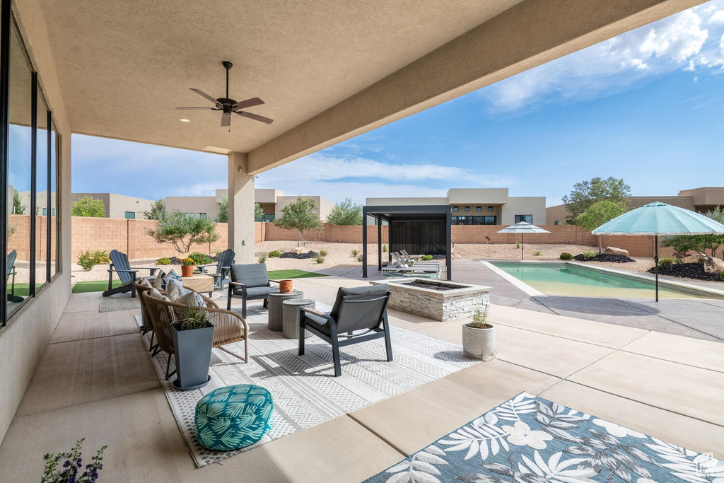Fenced backyard featuring a patio, a ceiling fan, and an outdoor hangout area