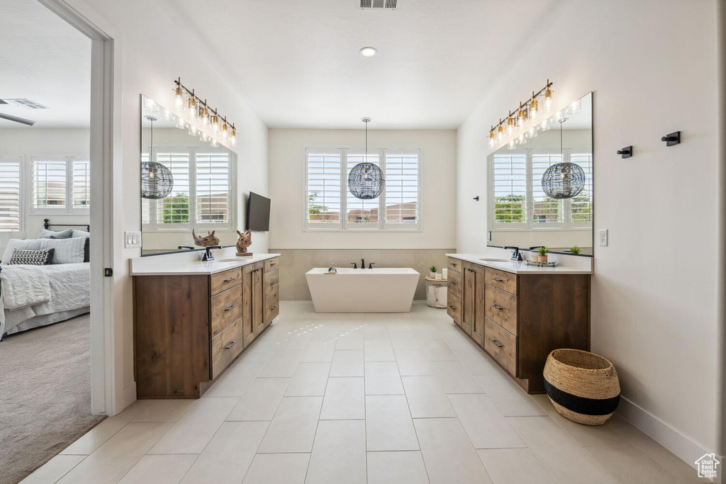 Ensuite bathroom with plenty of natural light, two vanities, and a soaking tub