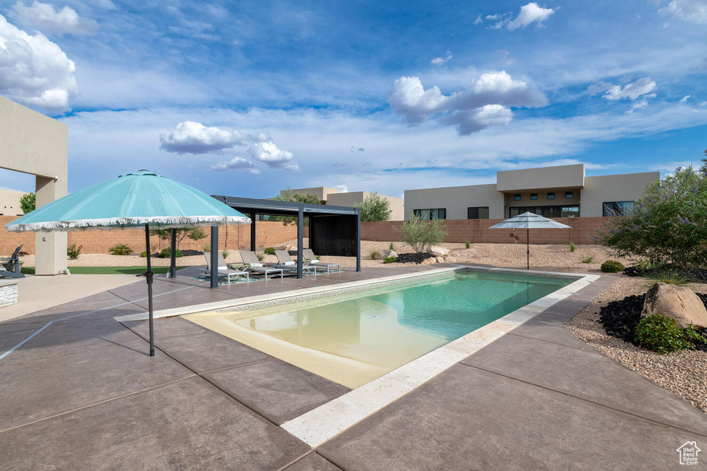 Outdoor pool featuring a fenced backyard and a patio area